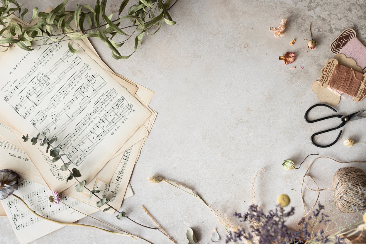 Music Sheets Near Dried Flowers on White Surface